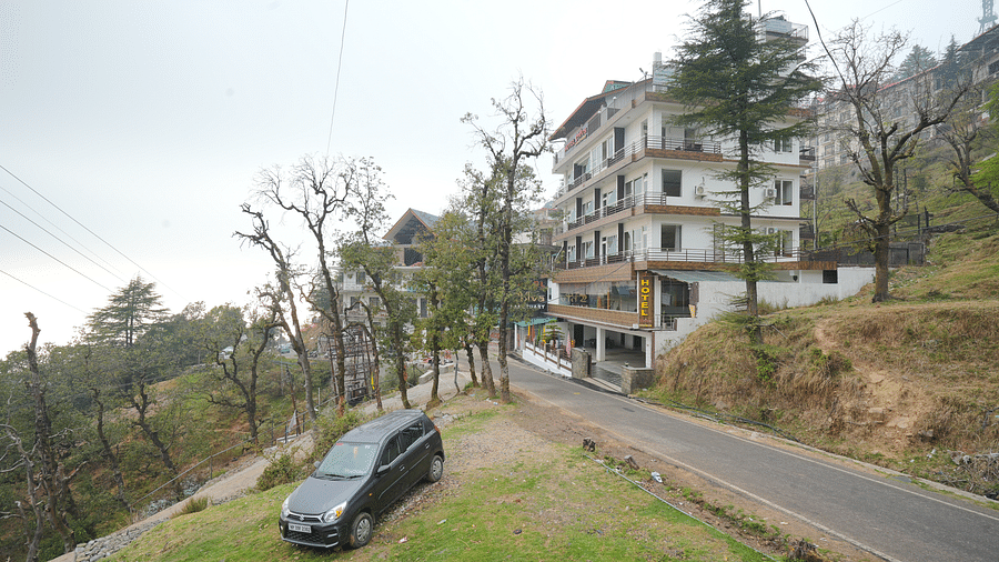 Image of the hotel from a side angle with trees in the background | DLS Hotel Shiva Sanctuary and Spa